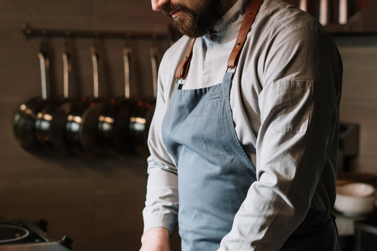 Chef in a denim apron preparing vegetables
