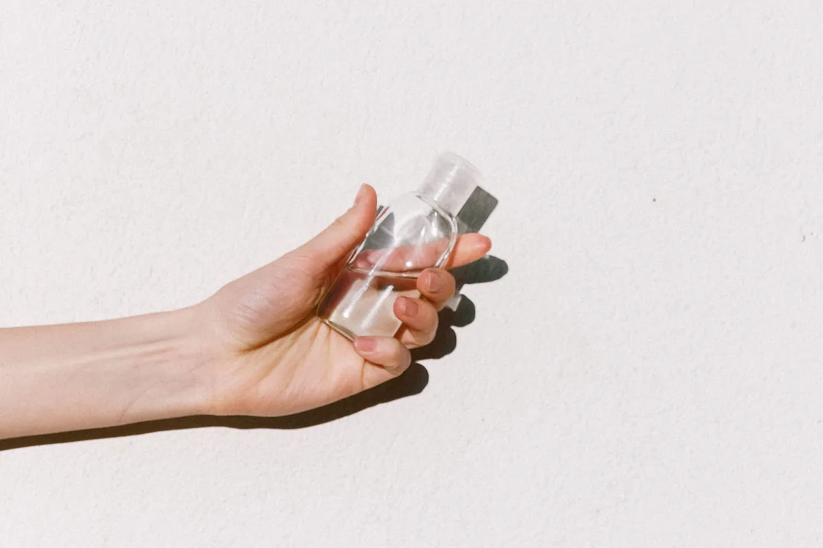 Person holding a bottle of hand sanitizer